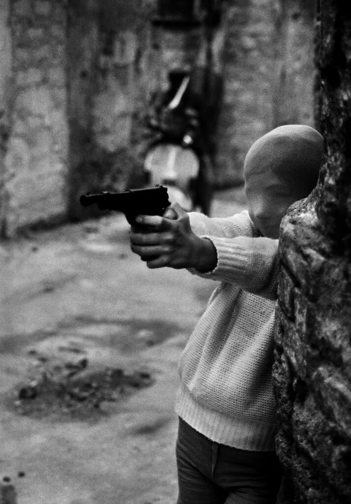 Letizia Battaglia: Letizia Battaglia, The killers’ game, near the Church of Santa Chiara, Palermo, 1982, Letizia Battaglia Archive. Corriere della Sera.
